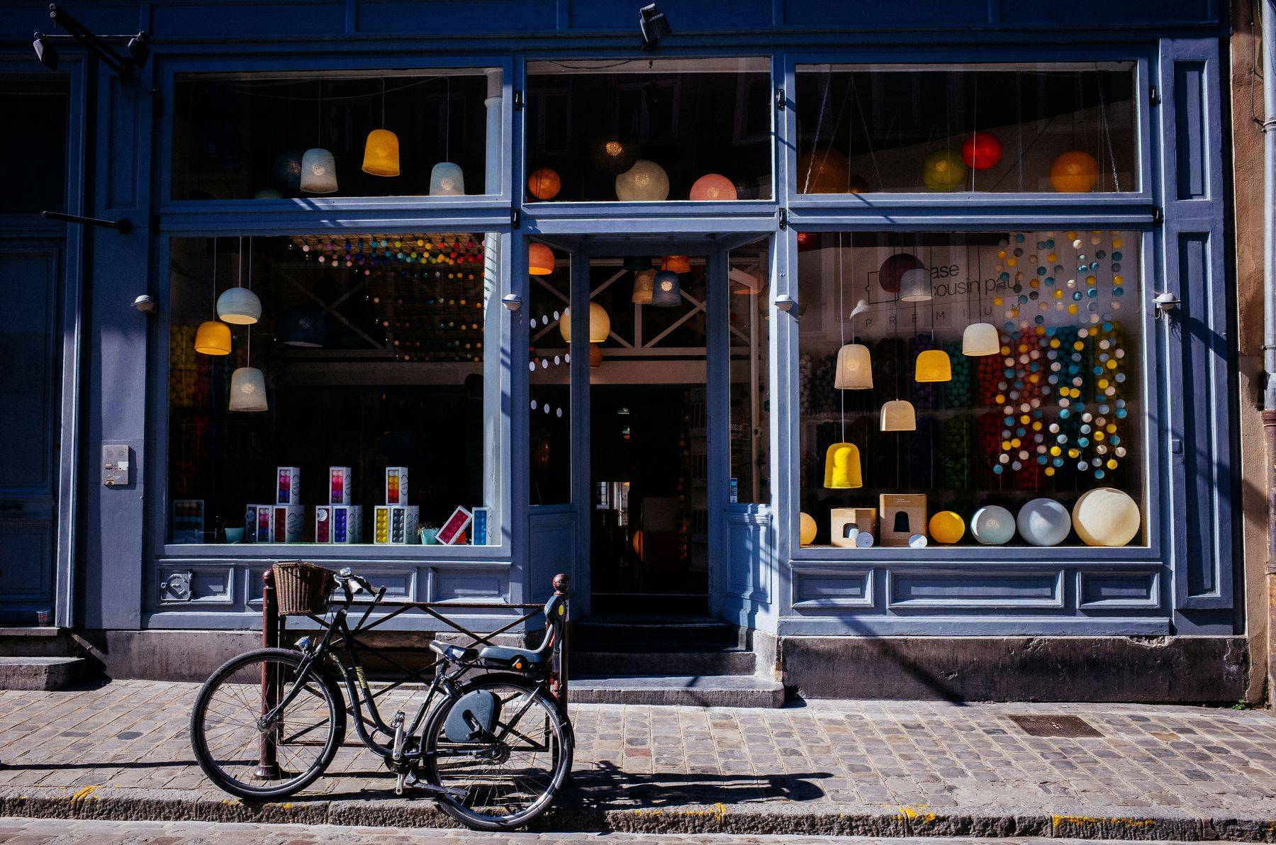 Escaparate de una tienda de barrio con una bicicleta aparcada delante